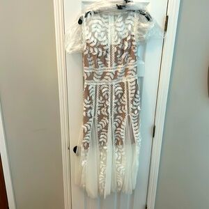A gently worn dress. Only worn once. White and tan dress with floral accents.